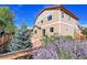 Backyard featuring a stone patio and landscaping including small tree and purple flowering bushes at 12762 Fisher St, Englewood, CO 80112