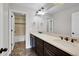 Bathroom featuring double sinks, dark wood cabinetry, and a walk-in shower in the background at 12762 Fisher St, Englewood, CO 80112