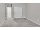Neutral bedroom featuring gray walls, carpet, closet with white sliding doors and an open doorway to the hallway at 12762 Fisher St, Englewood, CO 80112