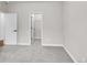 Empty bedroom featuring gray carpet, open doorway to closet and closed doorway to the hallway at 12762 Fisher St, Englewood, CO 80112
