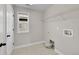 Functional laundry room with sleek tile flooring, modern shelving and all the necessary hookups at 12762 Fisher St, Englewood, CO 80112