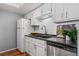 White kitchen cabinets and dark countertops with stainless steel appliances at 8600 E Alameda Ave # 13-108, Denver, CO 80247