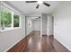 Bright bedroom featuring hardwood floors, mirrored closet doors, and a ceiling fan at 2113 Coronado Pkwy # B, Denver, CO 80229