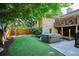 Landscaped backyard with green artificial turf and a hot tub, partially covered at 10601 E Crestline Ave, Englewood, CO 80111