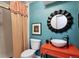 Colorful bathroom with a unique mirror, vibrant vanity, and shower showcasing a modern design at 10601 E Crestline Ave, Englewood, CO 80111
