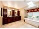 Well-lit bathroom featuring dual vanities, a soaking tub, and stylish tile accents at 10601 E Crestline Ave, Englewood, CO 80111