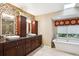 Beautiful bathroom featuring double sinks, tiled walls, and a luxurious soaking tub at 10601 E Crestline Ave, Englewood, CO 80111
