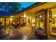 Covered deck at dusk with multiple seating areas, overlooking the landscaped yard at 10601 E Crestline Ave, Englewood, CO 80111