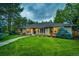Inviting single-story brick home with lush green lawn, mature trees, and a welcoming walkway to the front entrance at 10601 E Crestline Ave, Englewood, CO 80111