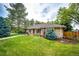 Charming brick home featuring a manicured lawn, mature trees, and beautiful landscaping at 10601 E Crestline Ave, Englewood, CO 80111