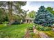 Well-manicured front yard showcasing lush landscaping, a brick home exterior, and mature trees at 10601 E Crestline Ave, Englewood, CO 80111