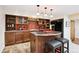 Basement kitchen with a unique island, warm lighting, updated appliances, and decorative backsplash at 10601 E Crestline Ave, Englewood, CO 80111