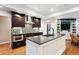 Modern kitchen featuring hardwood floors, stainless steel appliances, and a center island at 10601 E Crestline Ave, Englewood, CO 80111
