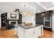 Gourmet kitchen featuring stainless steel appliances, an island with a breakfast bar, and designer lighting at 10601 E Crestline Ave, Englewood, CO 80111
