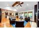 Open-concept living room with hardwood floors, vaulted ceiling, fireplace, and seamlessly connected kitchen and dining areas at 10601 E Crestline Ave, Englewood, CO 80111