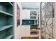 Walk-in pantry featuring hardwood floors and custom cabinets and shelving at 10601 E Crestline Ave, Englewood, CO 80111