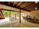 Covered patio with exposed wood beams, brick wall and outdoor dining with view of backyard and hot tub at 10601 E Crestline Ave, Englewood, CO 80111