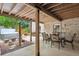 Covered patio with an outdoor dining set, landscaping, and a relaxing hot tub at 10601 E Crestline Ave, Englewood, CO 80111