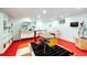 Playful recreation room featuring colorful furniture, unique lighting, and a fun red floor at 10601 E Crestline Ave, Englewood, CO 80111