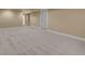 Large basement with neutral carpet and access to other rooms in the home at 3209 N Olive St, Denver, CO 80207