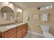 Well-lit bathroom featuring a double sink vanity and toilet at 3209 N Olive St, Denver, CO 80207