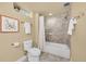 Neutral colored bathroom featuring a shower/tub combo, toilet, and decorative accents at 3209 N Olive St, Denver, CO 80207