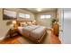 Cozy bedroom featuring wood floors, a wooden bed frame, and natural light from two windows at 3209 N Olive St, Denver, CO 80207