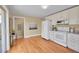 Open kitchen featuring white appliances, cabinetry, granite countertops and hardwood floors at 3209 N Olive St, Denver, CO 80207