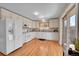 Bright kitchen with white cabinets, stainless appliances, granite counters, and hardwood floors at 3209 N Olive St, Denver, CO 80207