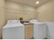 Bright laundry room with modern washer, dryer and a utility sink at 3209 N Olive St, Denver, CO 80207