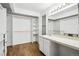 Bright bathroom featuring hardwood floors, a make-up vanity, and closet with storage at 18830 E 16Th Pl, Aurora, CO 80011