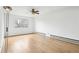 Bright bedroom featuring hardwood floors, a ceiling fan, and a large window at 18830 E 16Th Pl, Aurora, CO 80011