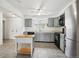 Well-lit kitchen featuring tile flooring, gray cabinets, modern appliances, and an island at 18830 E 16Th Pl, Aurora, CO 80011