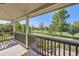 Relaxing covered porch with view of the green lawn and park featuring mature trees at 3080 Madison Ln, Broomfield, CO 80023