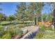 Scenic backyard view featuring lush landscaping, a paved patio, and a charming white fence at 3080 Madison Ln, Broomfield, CO 80023
