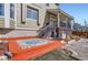 Charming home exterior with vibrant colored patio and classic wood stairs and railing at 3080 Madison Ln, Broomfield, CO 80023