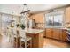 Open kitchen with stainless steel appliances, granite countertops, kitchen island with stools, and hardwood floors at 3080 Madison Ln, Broomfield, CO 80023