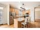 Kitchen island with granite countertops and pendant lighting overlooking the stainless steel refrigerator at 3080 Madison Ln, Broomfield, CO 80023