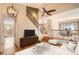 Bright living room featuring hardwood floors, modern ceiling fan and light fixture, and staircase to a dining room at 3080 Madison Ln, Broomfield, CO 80023