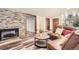 Living room featuring a fireplace with stone wall and comfortable leather seating at 3080 Madison Ln, Broomfield, CO 80023