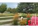 Serene park view with lush grass, walking path and flowers in front of a white fence at 3080 Madison Ln, Broomfield, CO 80023