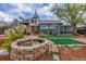Backyard with stone fire pit, manicured lawn, and uniquely designed home at 15785 W Second Ave, Golden, CO 80401