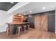 Finished basement with bar, seating, barn door, and wood flooring, perfect for entertaining at 7756 S Eaton Park Ct, Aurora, CO 80016