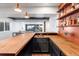 Finished basement bar with stylish wood countertop, copper sink, and custom shelving with decorative lighting at 7756 S Eaton Park Ct, Aurora, CO 80016
