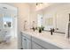Bright bathroom features double sinks, stone countertops, stylish lighting, and modern fixtures at 7756 S Eaton Park Ct, Aurora, CO 80016