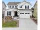 Charming two-story home with a white exterior, stone accents, a two-car garage, and manicured landscaping at 7756 S Eaton Park Ct, Aurora, CO 80016