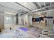 Spacious unfinished basement with exposed ceiling, concrete floors, exercise equipment, and a water heater at 1884 Myron Ct, Erie, CO 80516