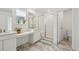 Bright bathroom with dual vanity, shower with glass door, and greenery accents at 1884 Myron Ct, Erie, CO 80516