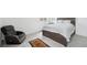 Relaxing bedroom featuring a chair, a bed with a nightstand, and bright windows at 1884 Myron Ct, Erie, CO 80516