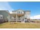 Back exterior view of a modern home featuring a spacious backyard and a charming covered porch at 1884 Myron Ct, Erie, CO 80516